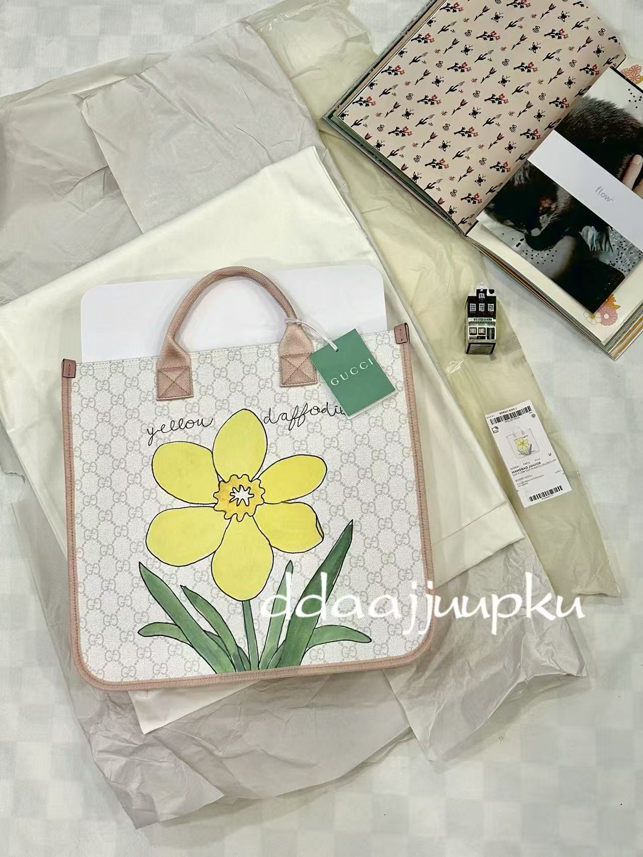 Floral tote bag styled with fashion books and soft textiles