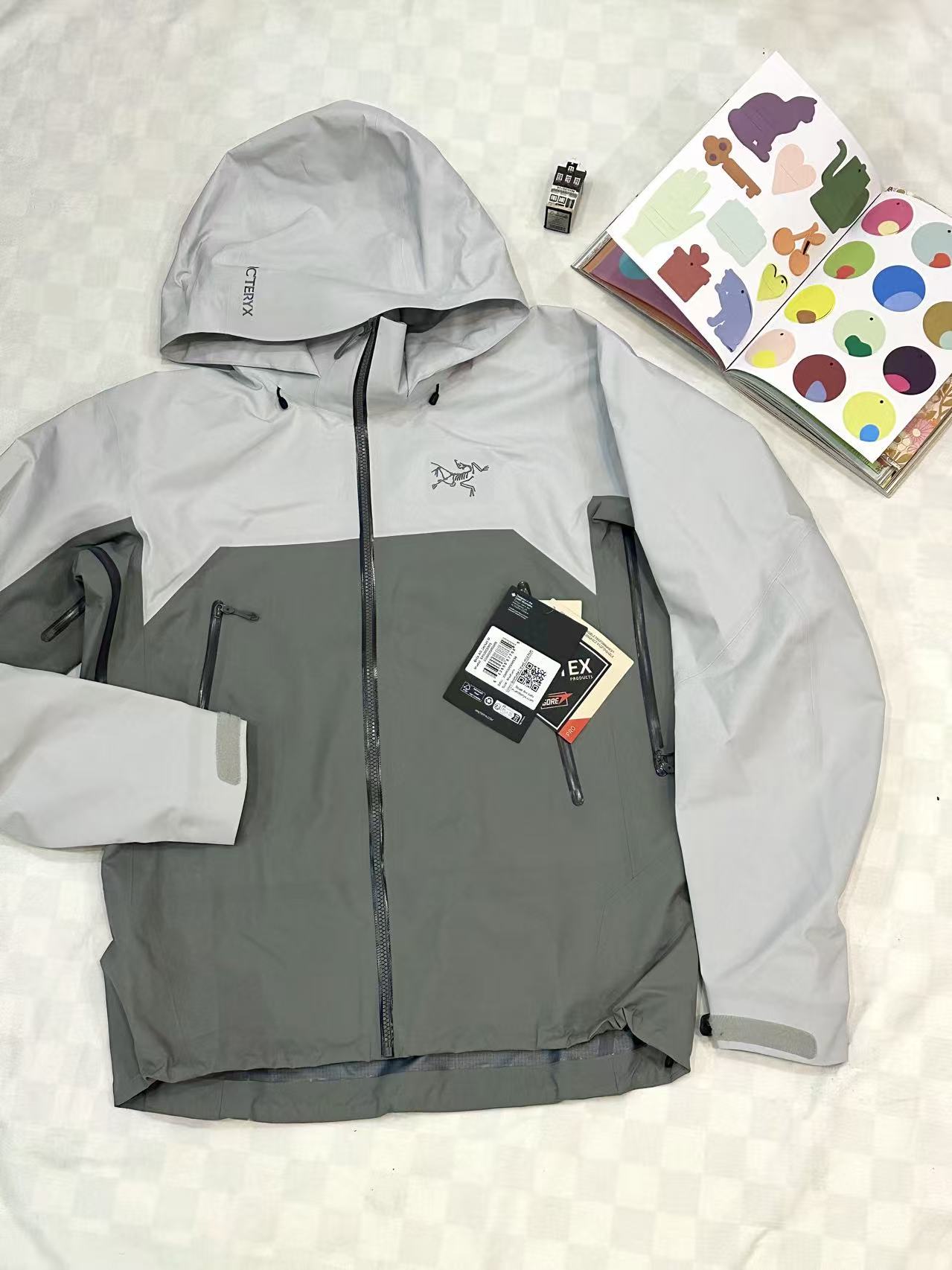 Grey technical hooded jacket styled on a light background