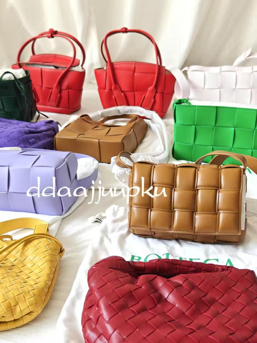 A colourful edit of woven handbags arranged in a bright studio setting